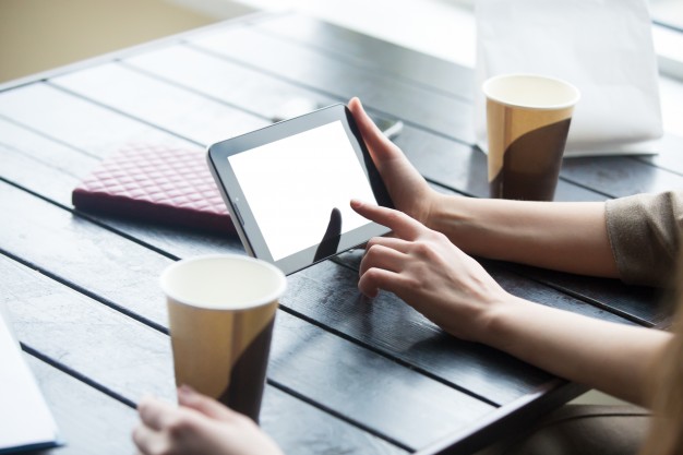 women-hands-holding-tablet-with-white-blank-screen-cafe-close-up_1163-1644